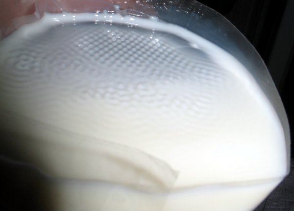 Avec du lait, une demi-bouteille en plastique et de la cellophane, il est possible d'observer des motifs géométriques de ce genre (ondes de Faraday)